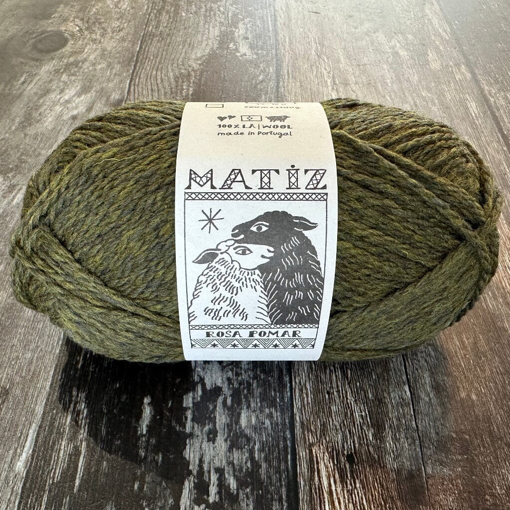 Green skein of yarn with a label on a wooden surface