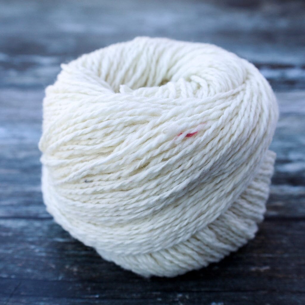 white ball of yarn on wooden surface