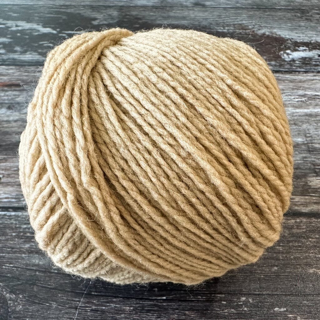 Ball of sand yarn on a wooden surface
