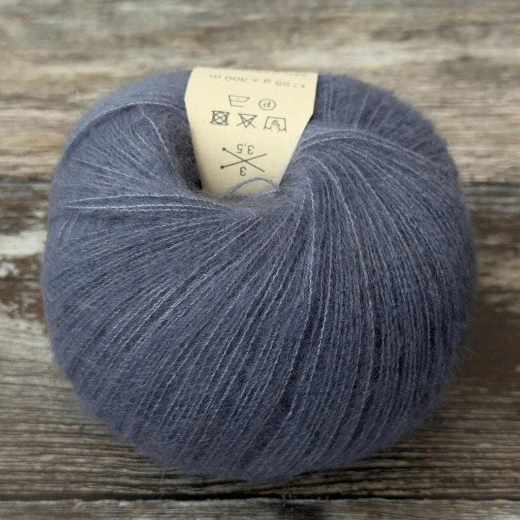 Ball of dark blue yarn with a label on a wooden surface