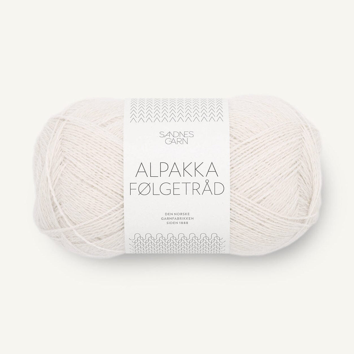 A skein of off-white alpaca wool yarn with a white paper label reading 'SANDNES GARN ALPAKKA FØLGETRÅD' on a light cream background.