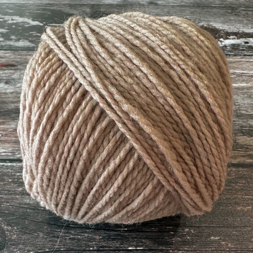 Ball of light brown yarn on a wooden surface