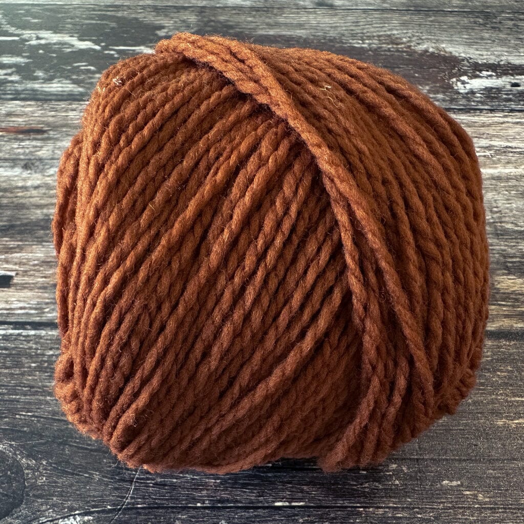 Brown skein of yarn on a wooden surface