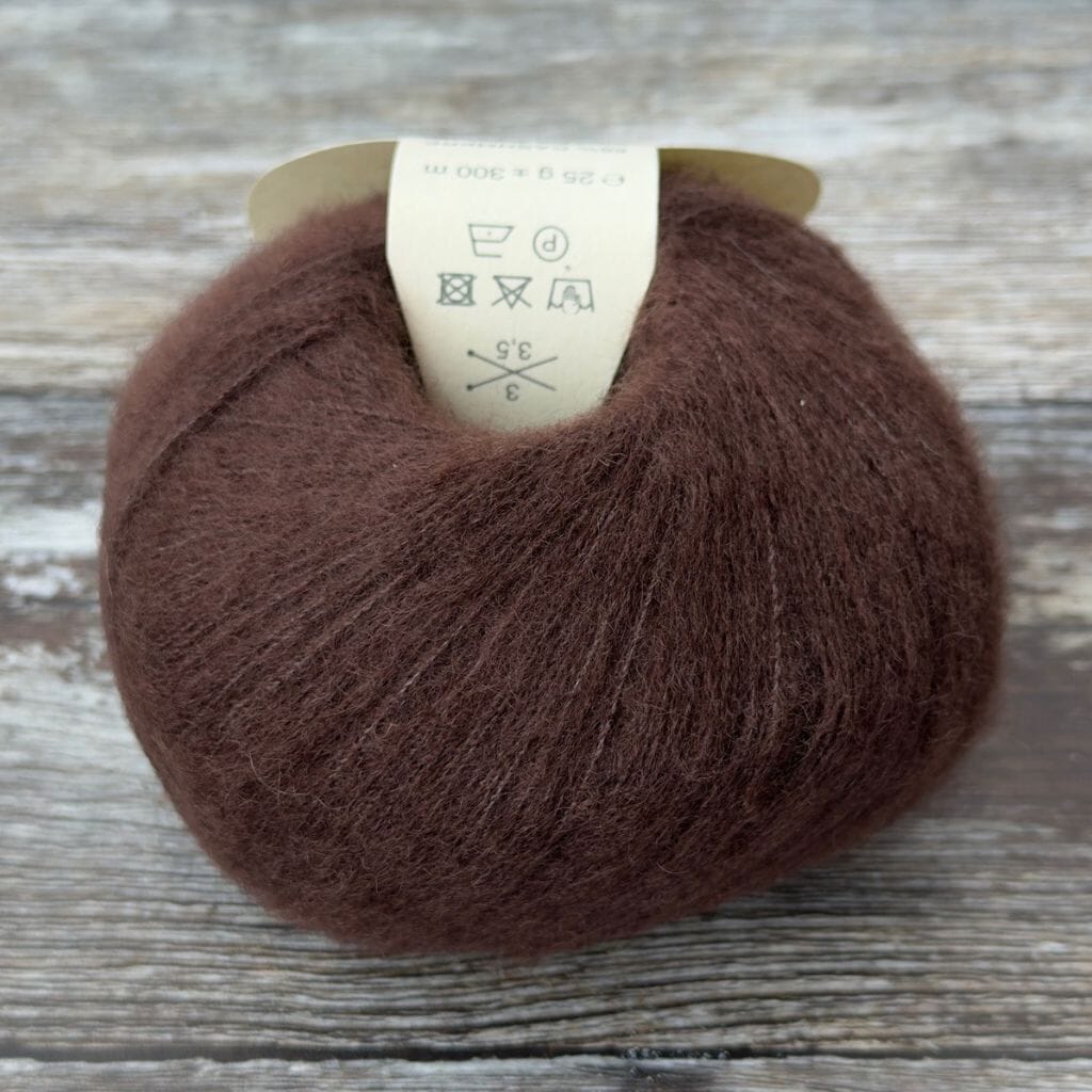Brown yarn ball with a label on a wooden surface