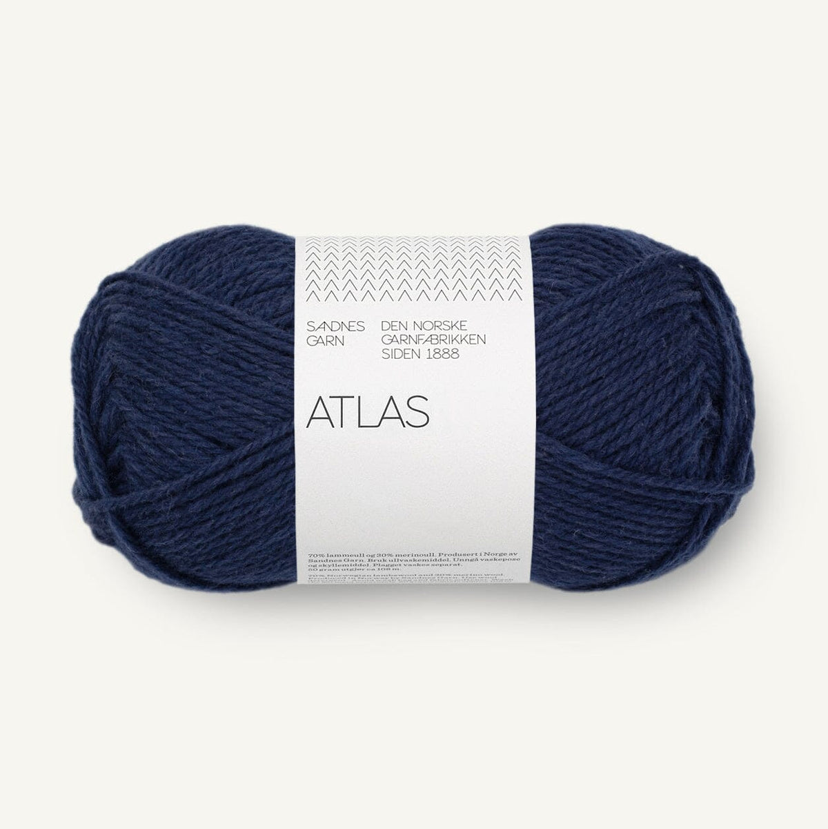 Navy blue skein of yarn with a white label on a light gray background
