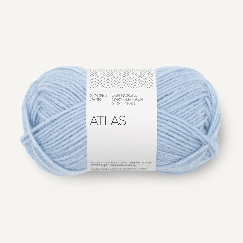 A ball of light blue yarn with a white paper label reading 'ATLAS' and 'SANDNES garn', photographed on a clean off-white background.