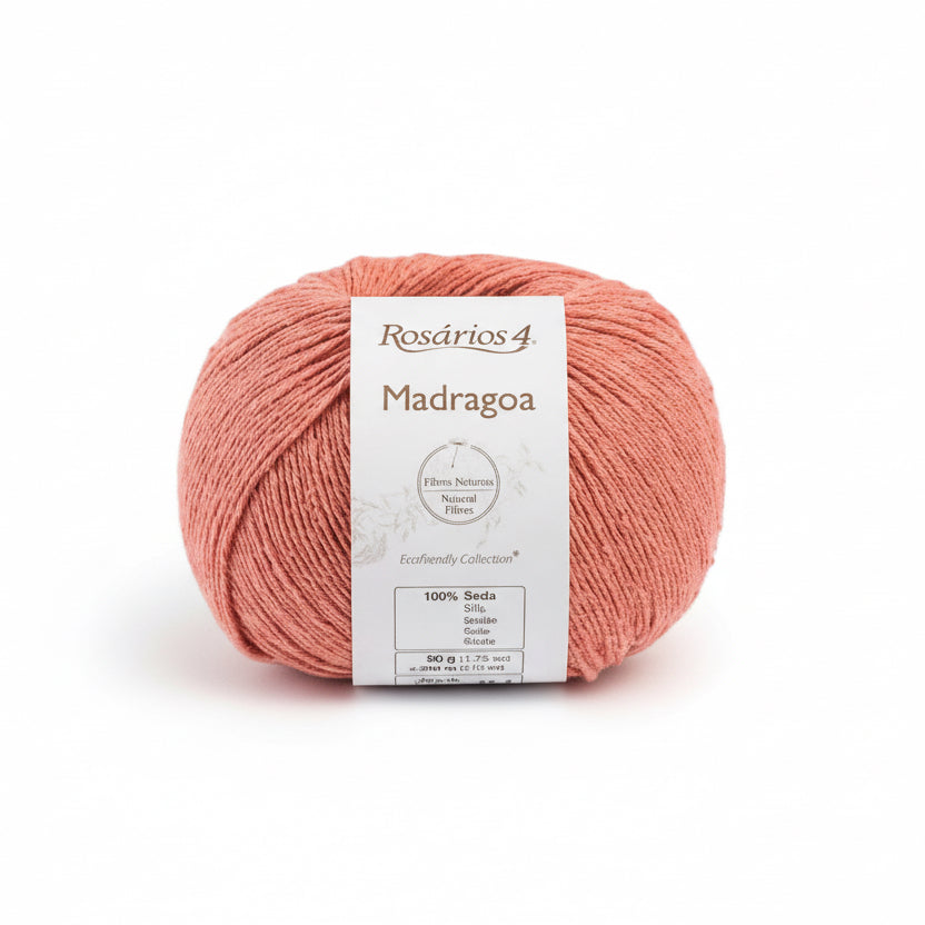 Coral skein of silk yarn with a label on a white background