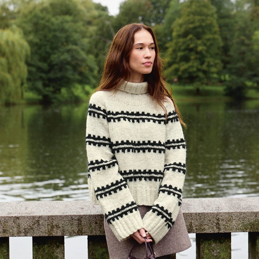 women wearing knitted sweater holding handbag