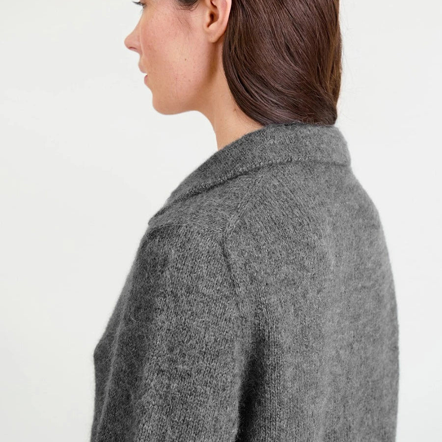 Person wearing a grey Jumper  against a white background