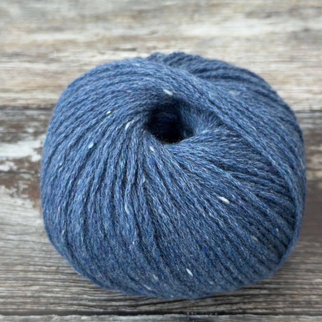 Blue skein of yarn on a wooden surface