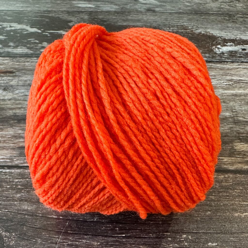 orange ball of yarn on a wooden surface
