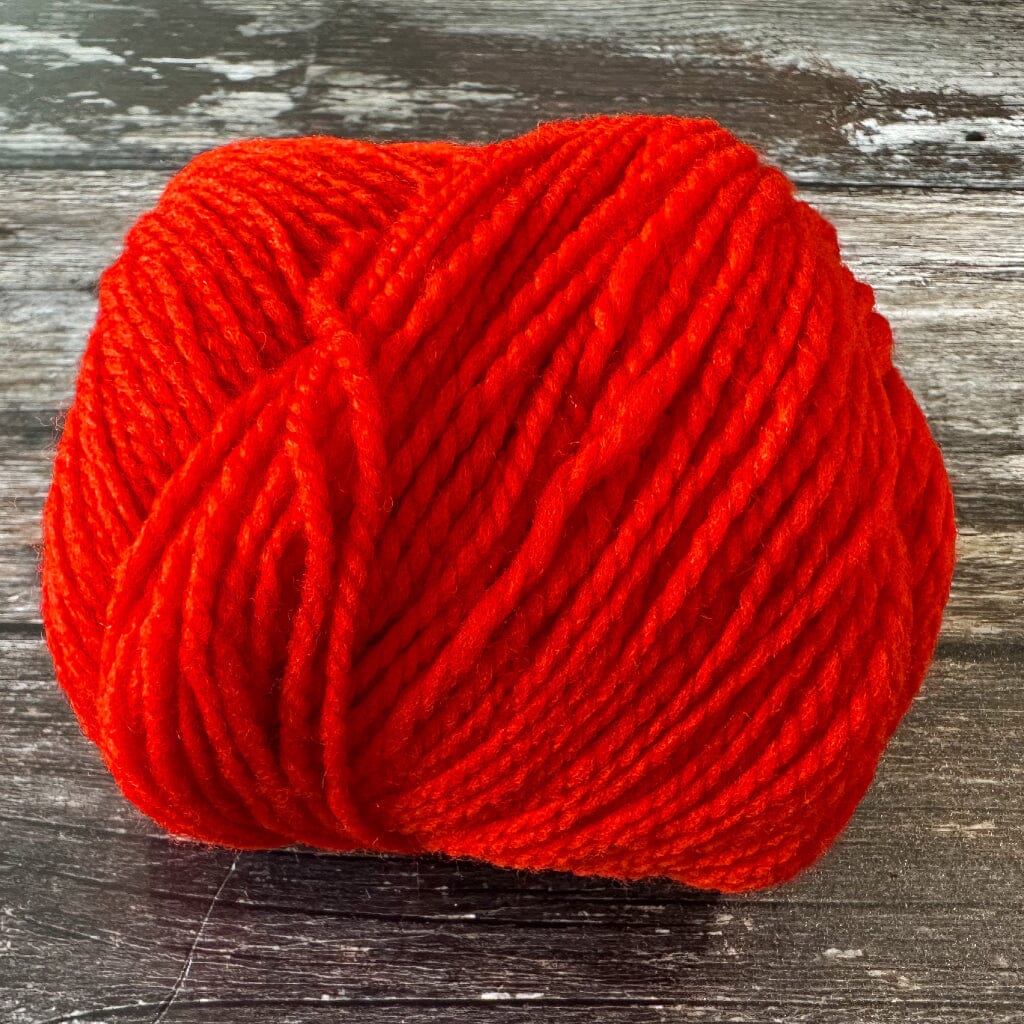 Red ball of yarn on a wooden surface