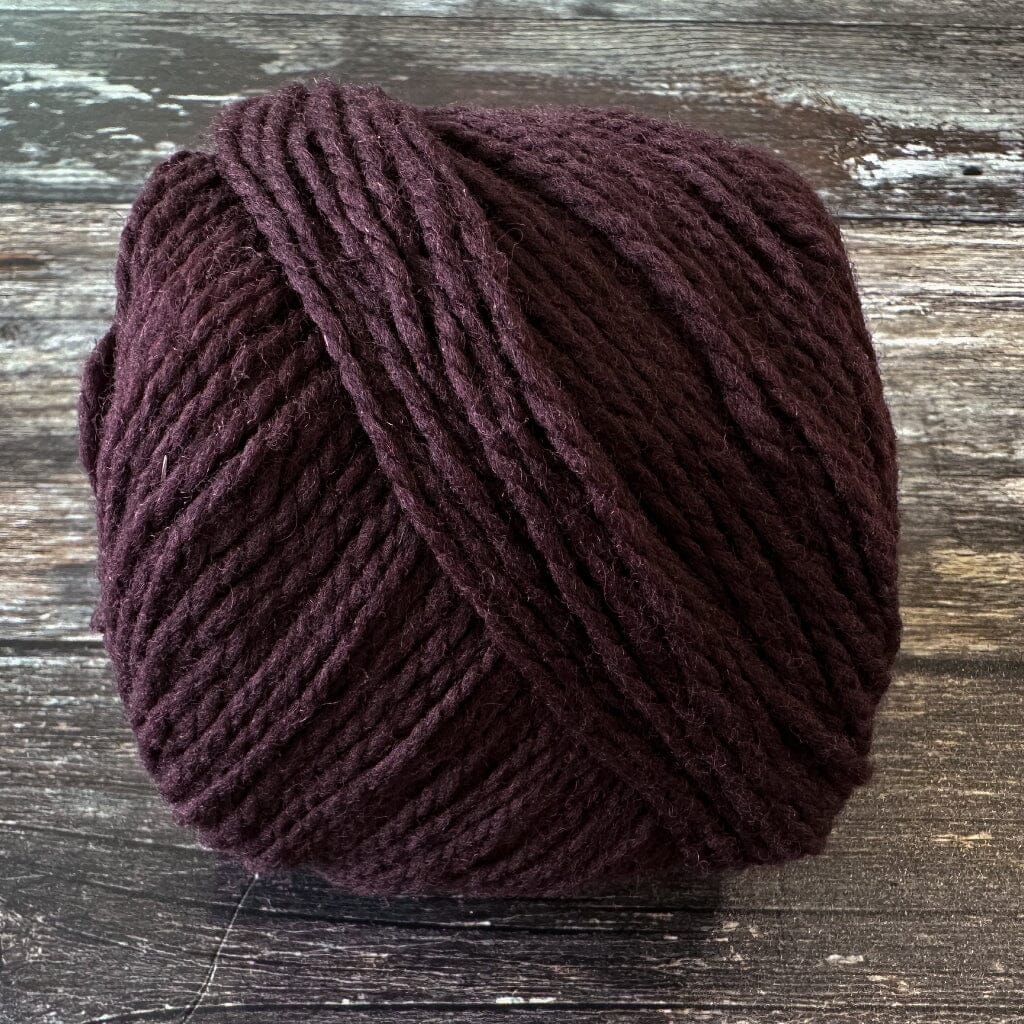 eggplant coloured yarn on a wooden surface