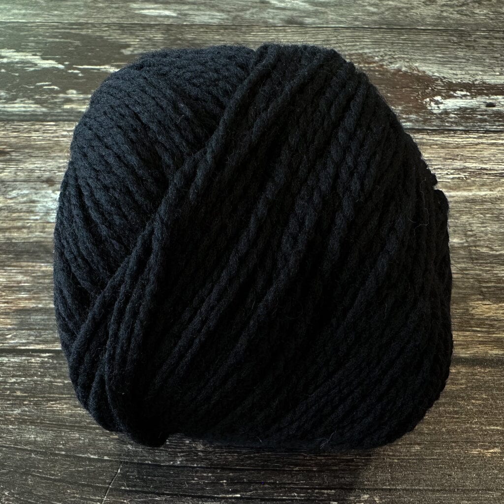 Black yarn ball on a wooden surface