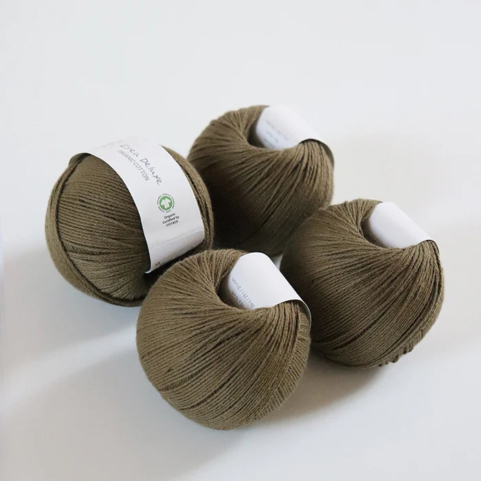 Four skeins of brown yarn with labels on a white background