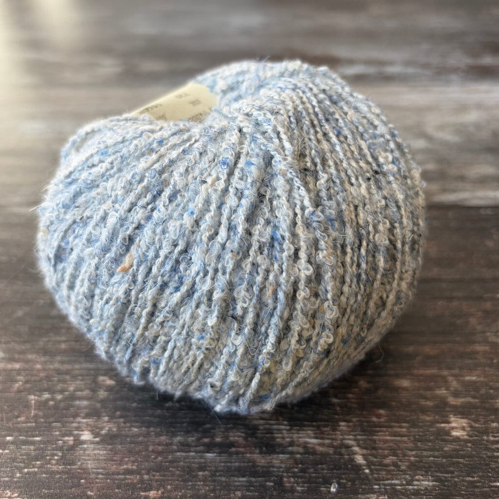 light blue boucle cotton yarn on wooden surface