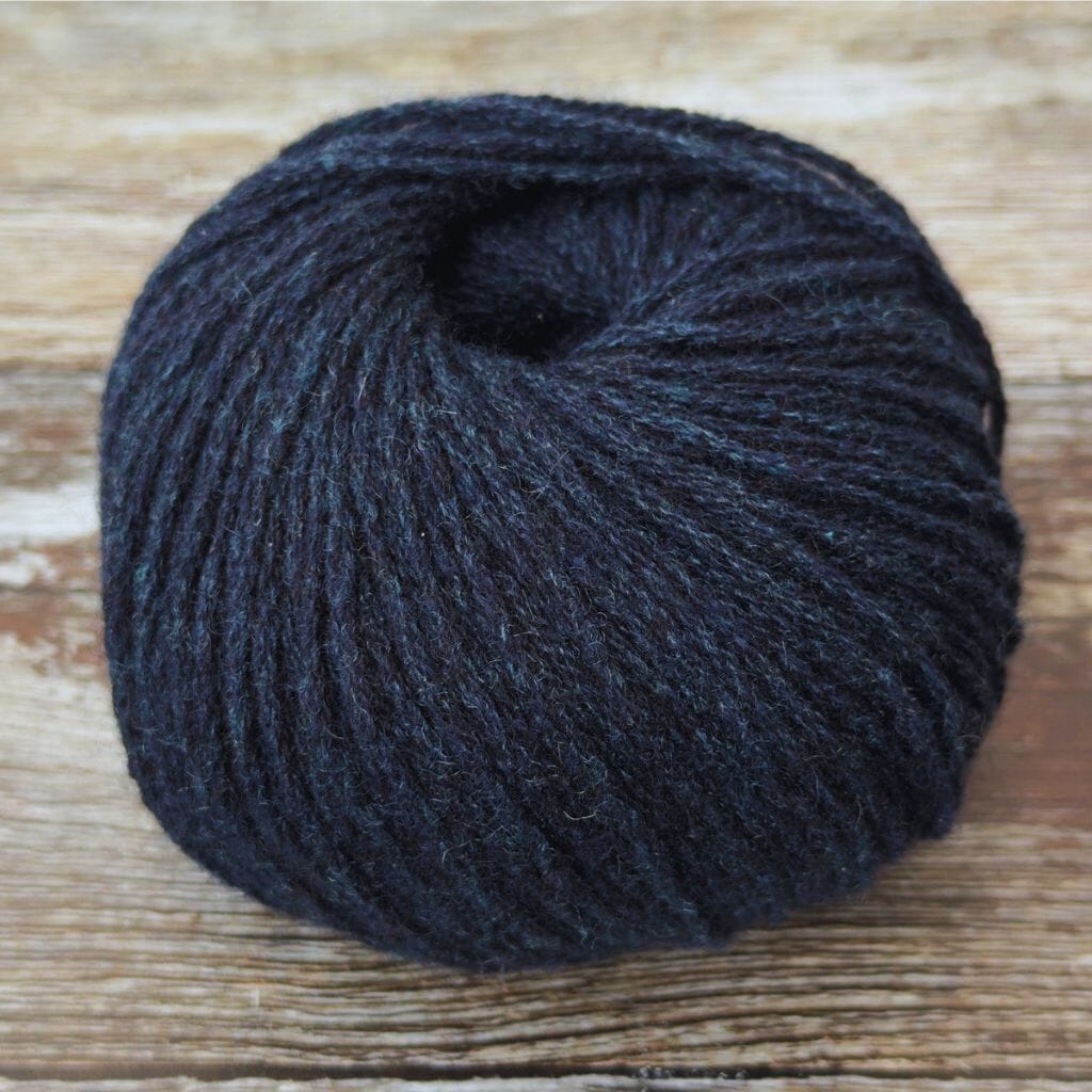 Dark blue skein of yarn on a wooden surface