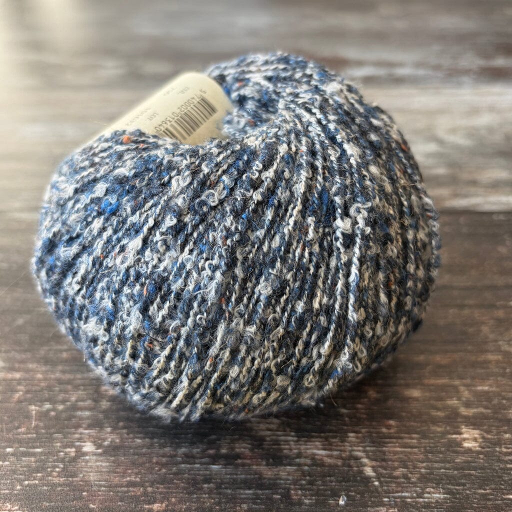 blue boucle cotton yarn on wooden surface
