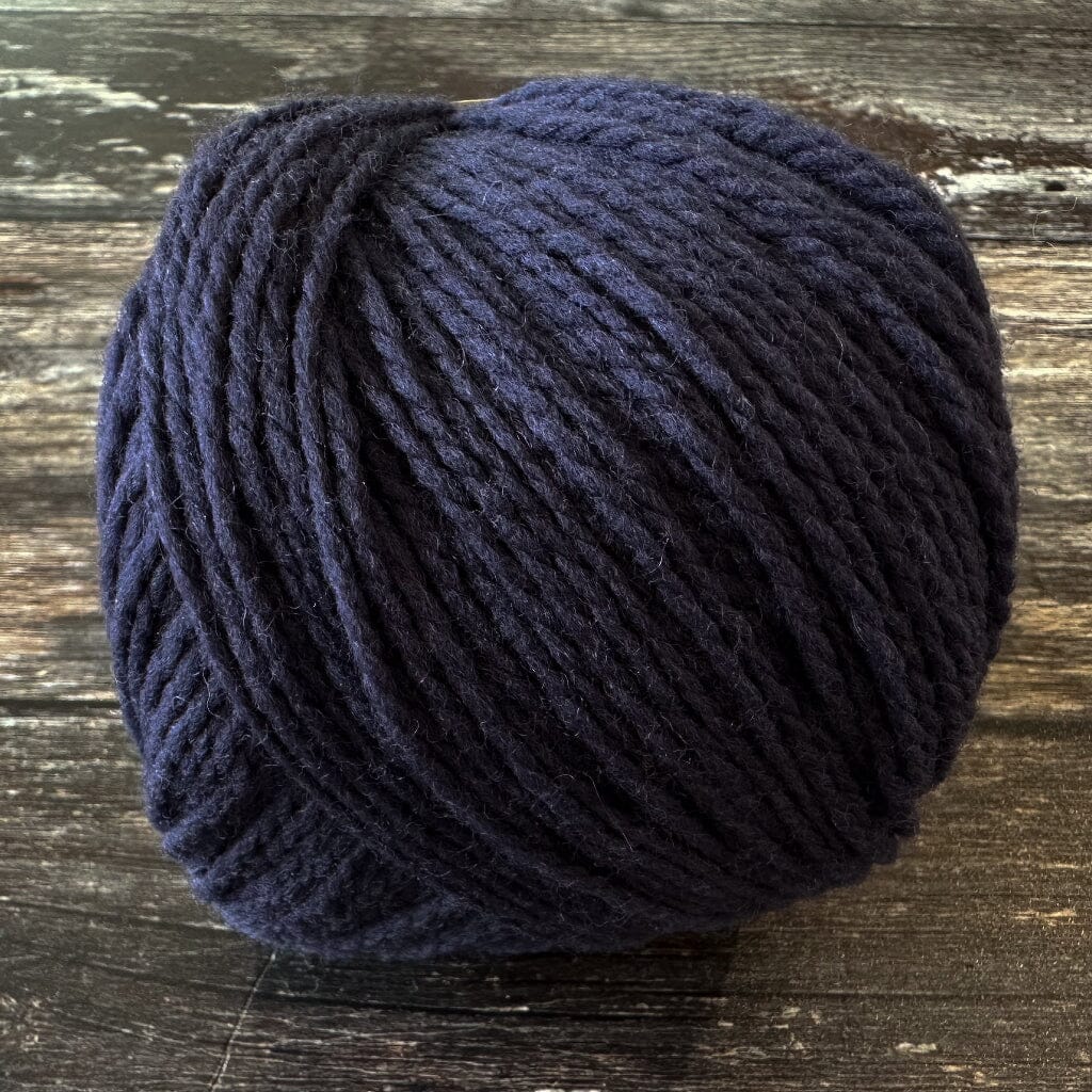 Navy blue skein of yarn on a wooden surface