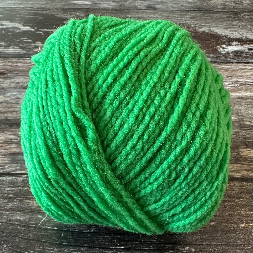 Green ball of yarn on a wooden surface