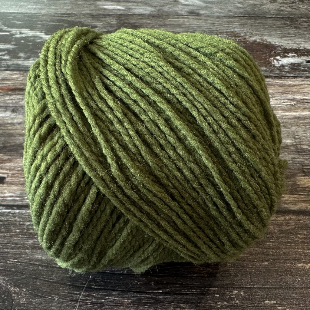 Green skein of yarn on a wooden surface