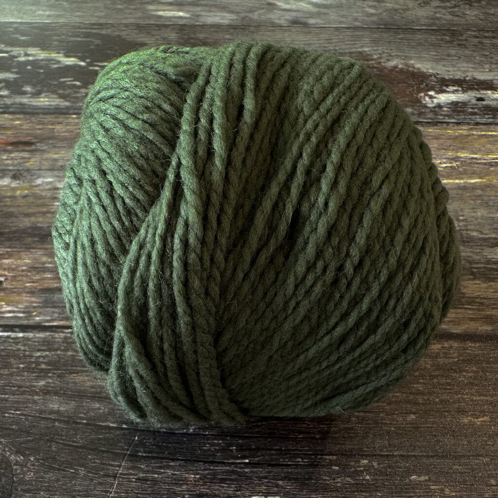 Green skein of yarn on a wooden surface