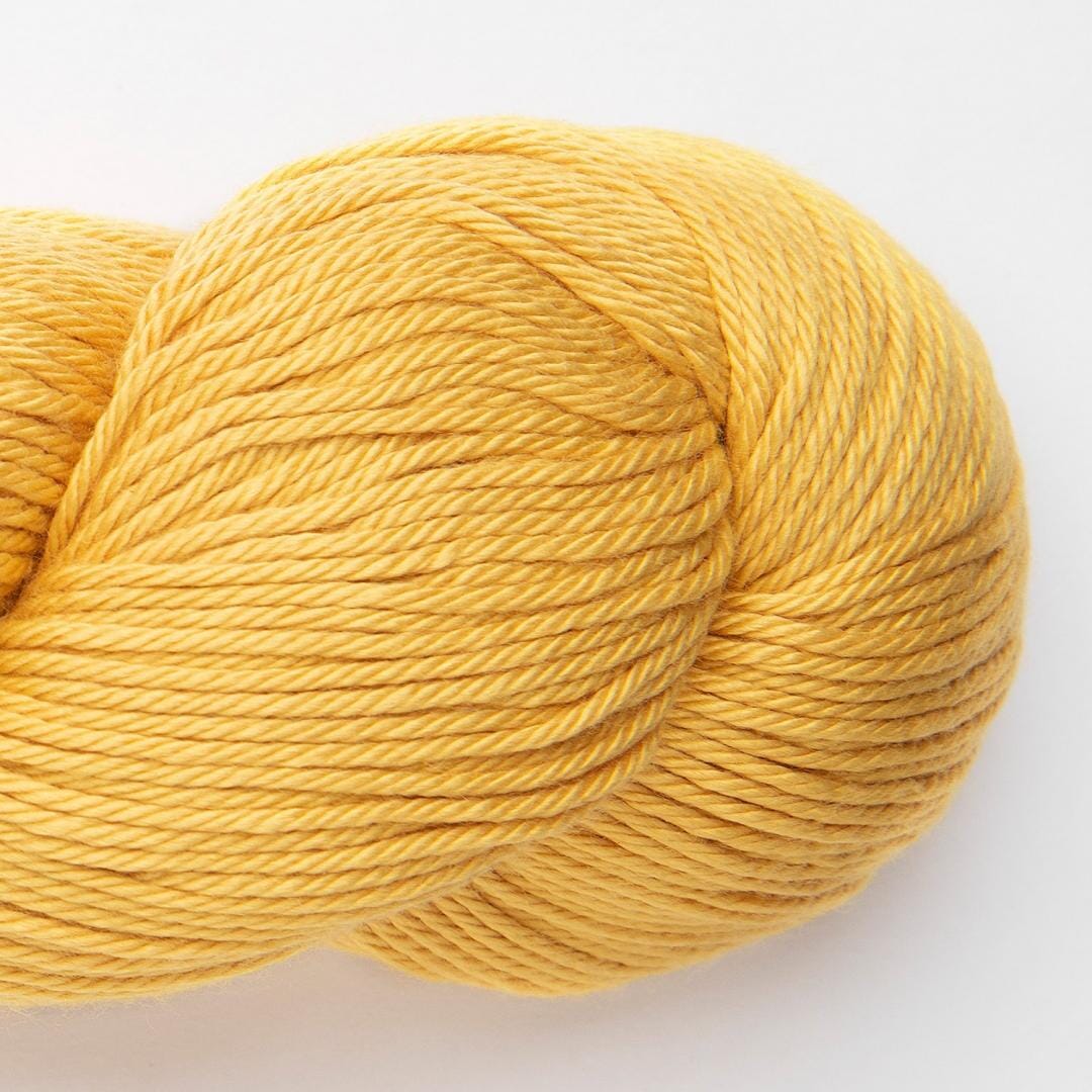 Bundles of yarn in various colors including blue, red, yellow, and beige, with a label that reads 'Samay' and indicates the yarn is made from cotton and bamboo.