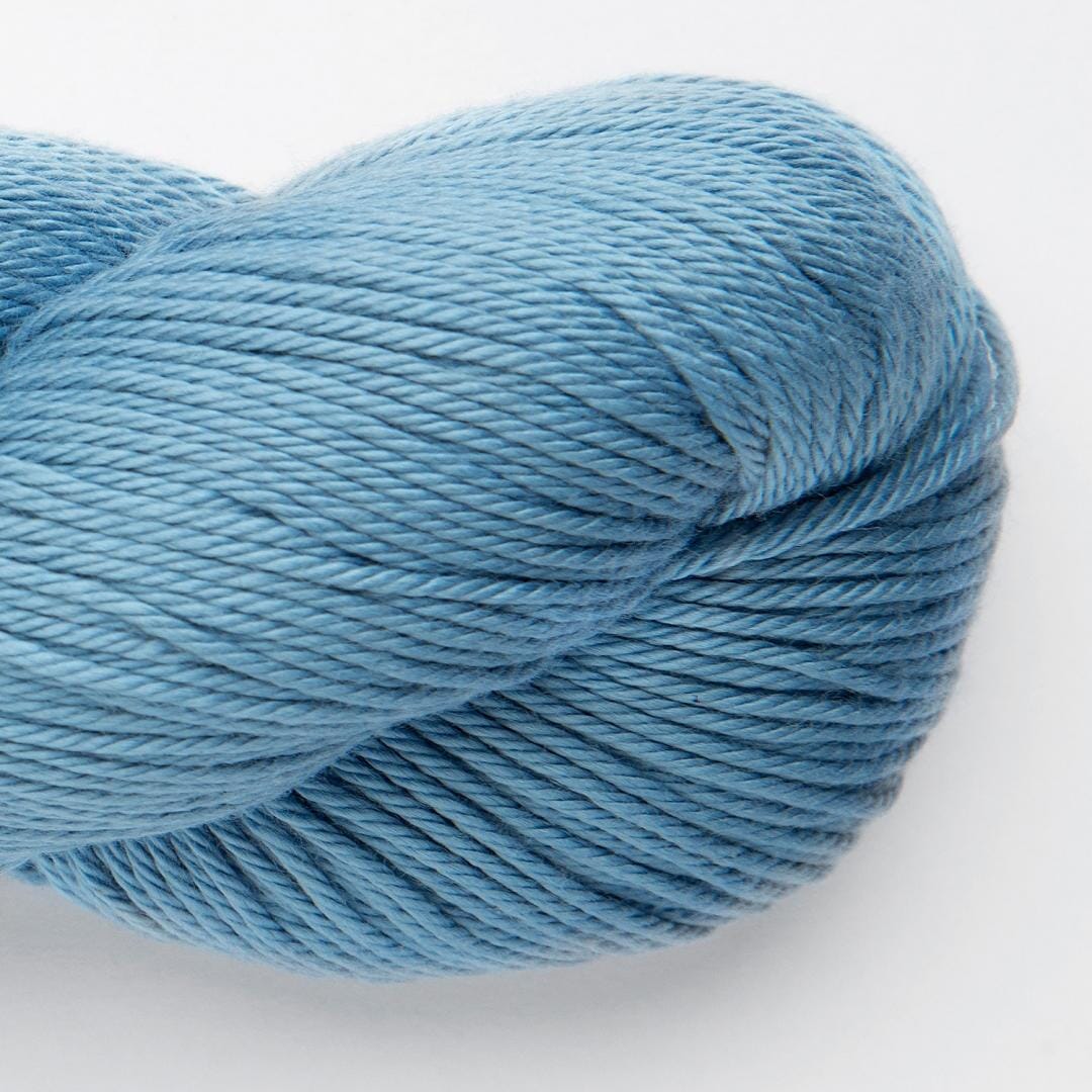 Bundles of yarn in various colors including blue, red, yellow, and beige, with a label that reads 'Samay' and indicates the yarn is made from cotton and bamboo.