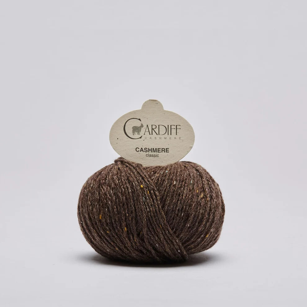 A ball of brown cashmere yarn with a paper tag reading 'CARDIFF  CASHMERE classic' on a light gray background.