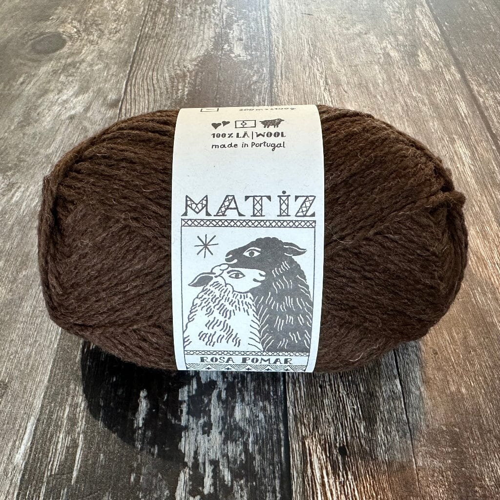 Brown yarn ball with a label on a wooden surface