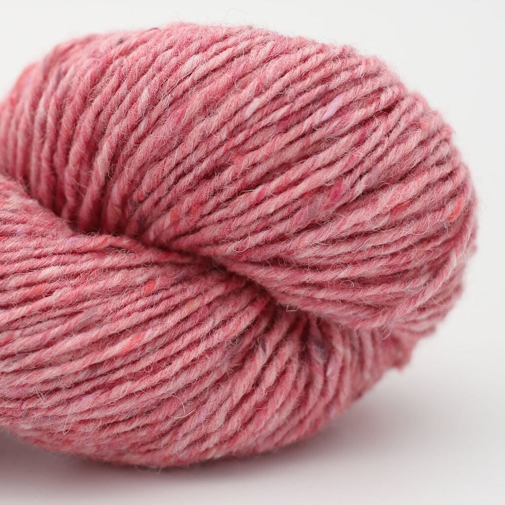 A close-up of a pink variegated skein of yarn on a clean white background.