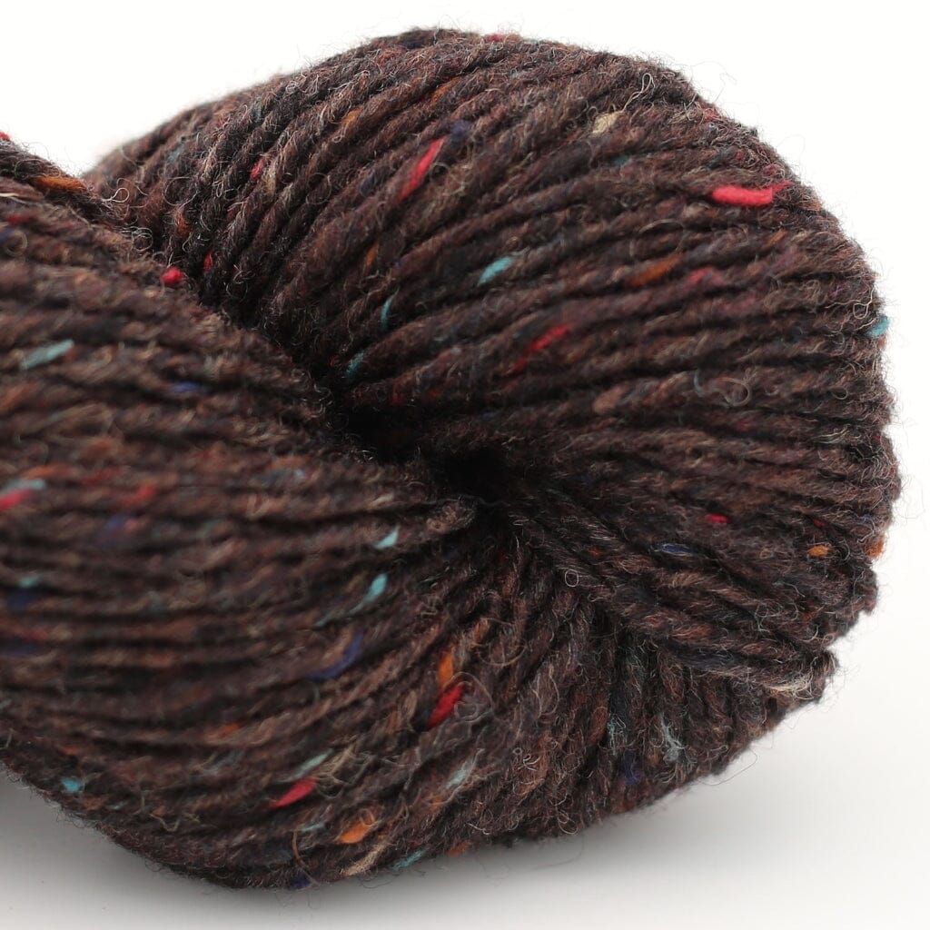 A close-up of a skein of dark brown variegated yarn with small multicolored flecks, photographed on a clean white background.