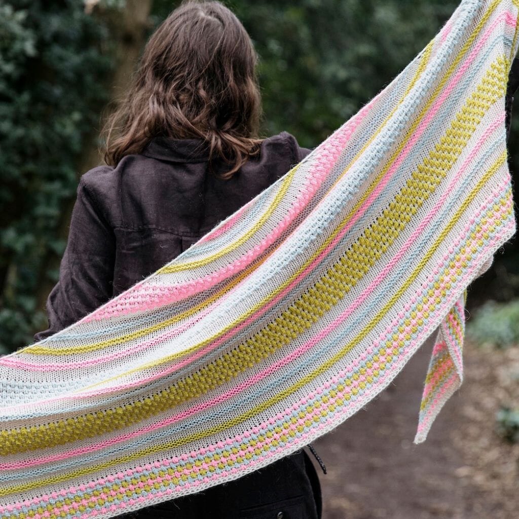 Person wearing a colourful striped shawl outdoors