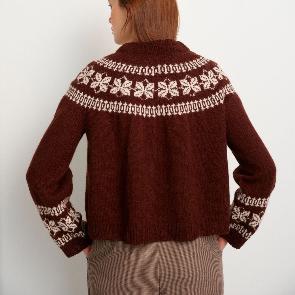 Brown knitted sweater with white pattern on a plain background