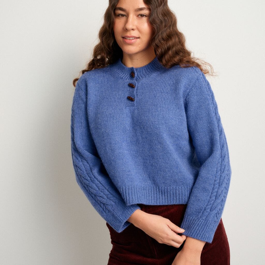 Woman wearing a blue sweater against a plain background
