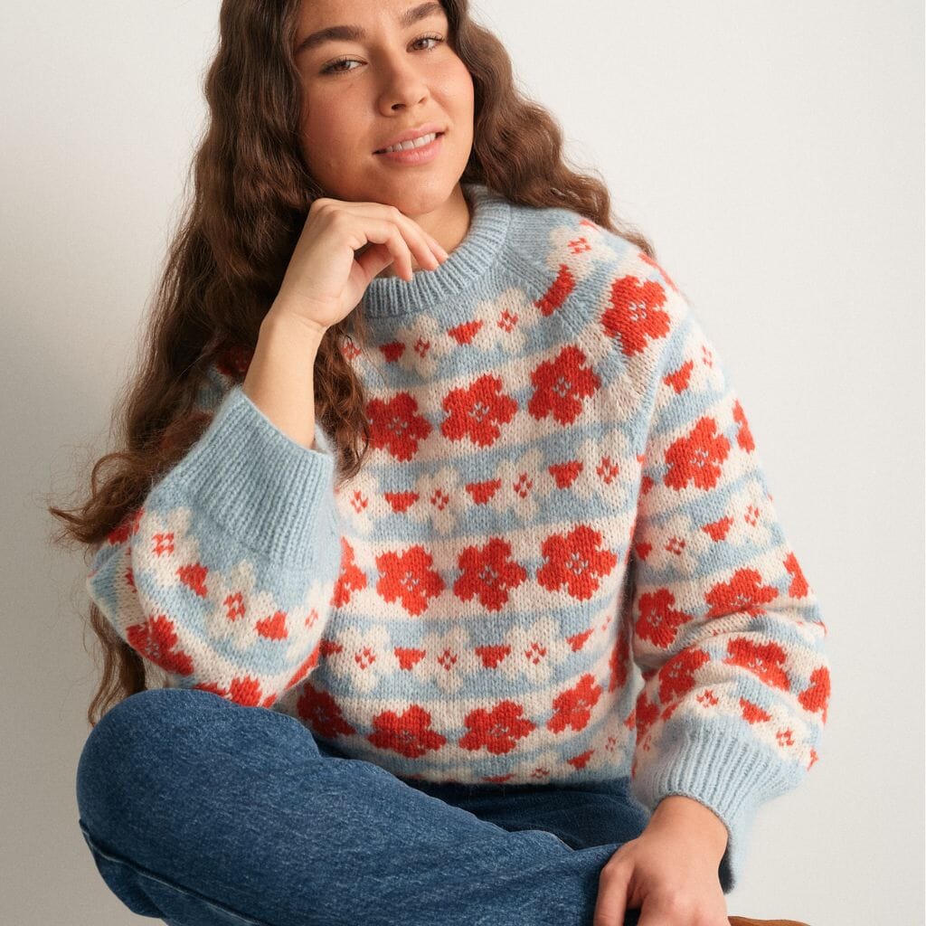 Woman wearing a floral sweater with a neutral background