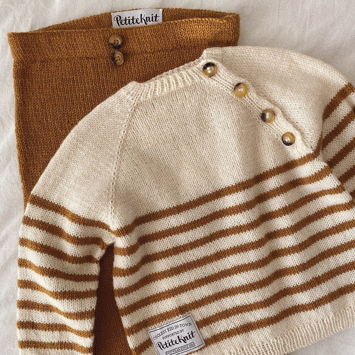 Knitted sweater with brown and white stripes on a light background