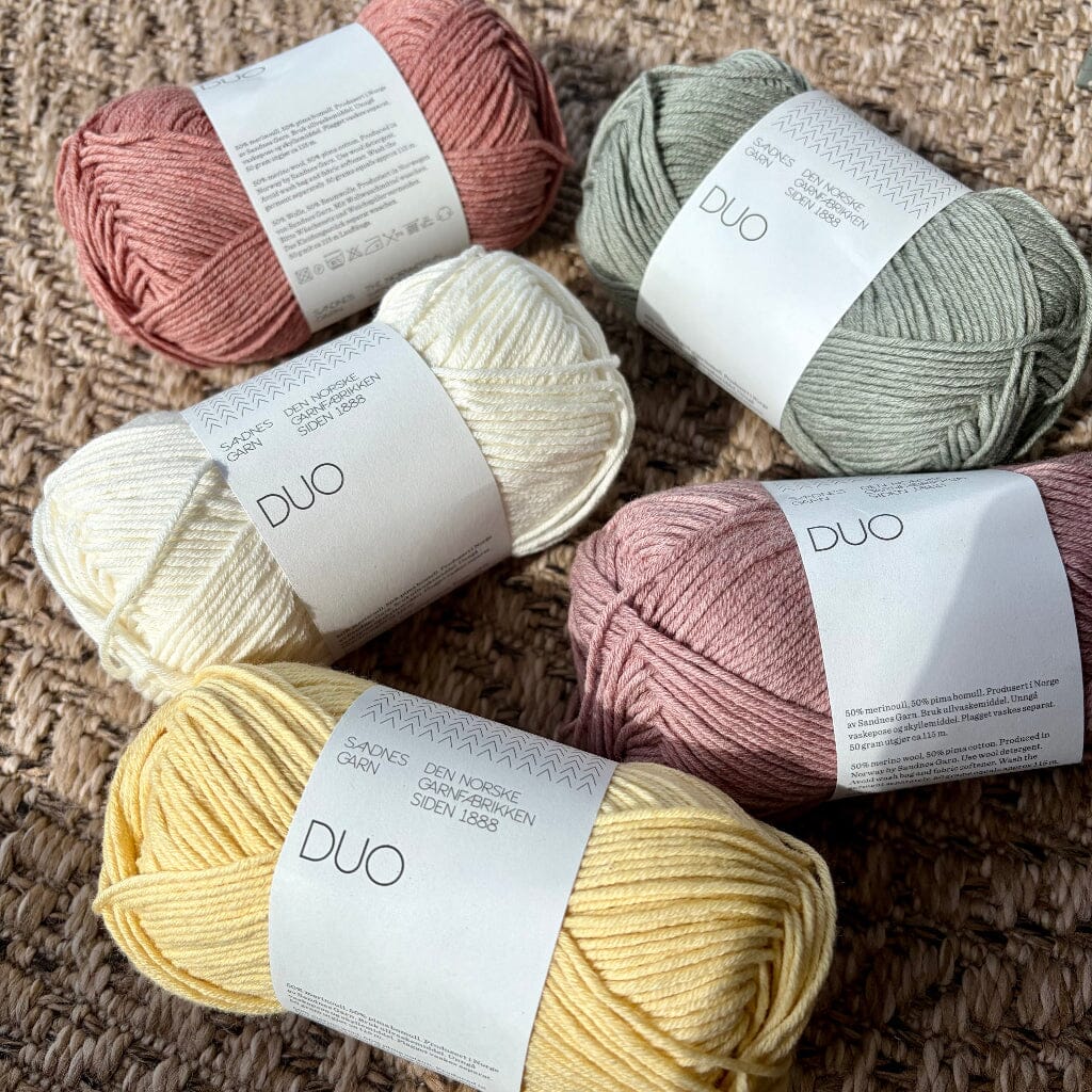 Five Balls of yarn in different colors with 'DUO' labels on a textured surface.