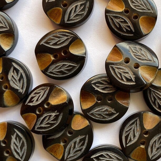 Decorative buttons with leaf pattern on a white background
