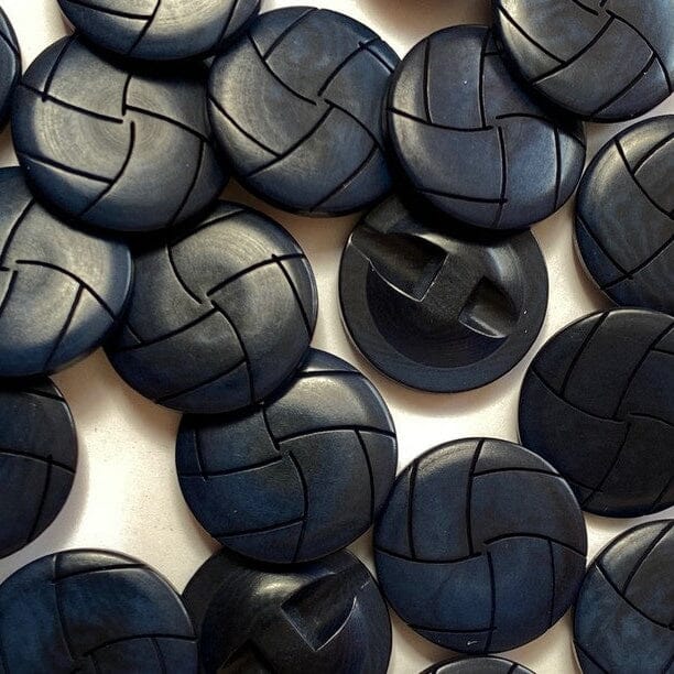 Close-up of navy woven corozo buttons on a white background