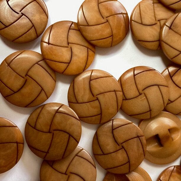 Close-up of woven wooden buttons on a white background