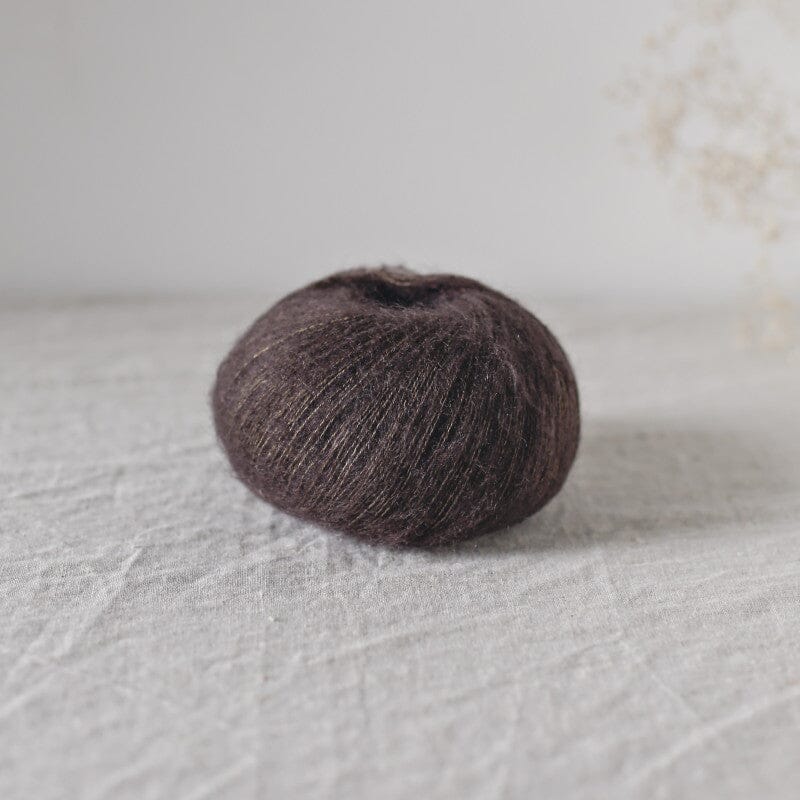 Brown mohair ball on a textured light gray surface