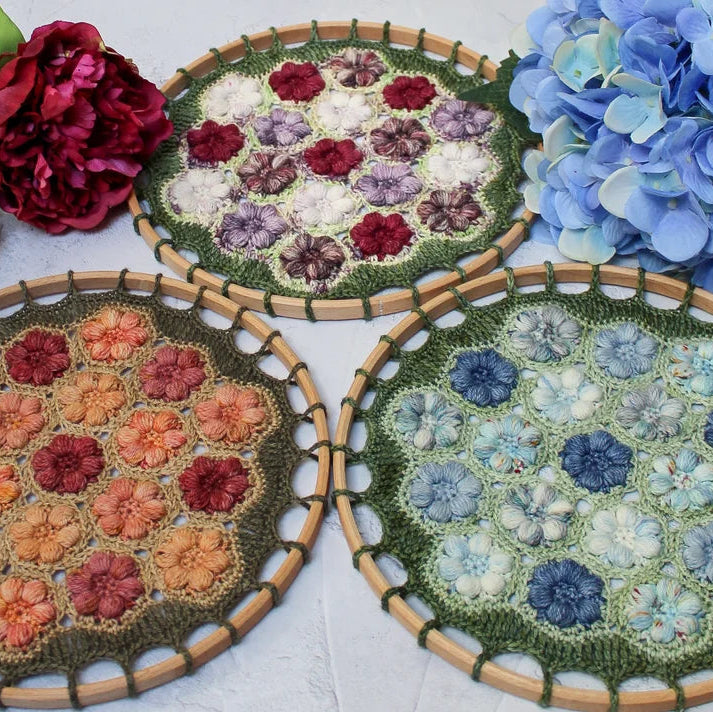Three circularmandalas with floral patterns on a white surface with flowers around.