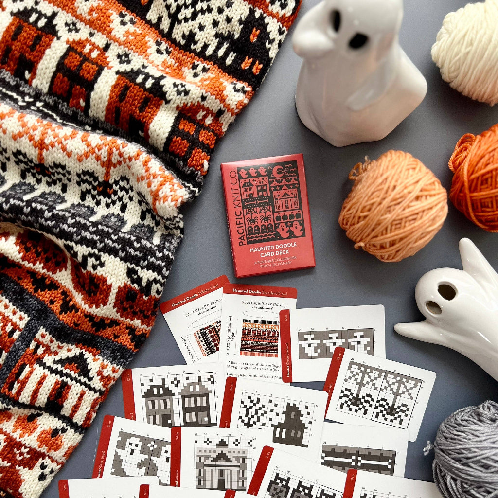 Knitting patterns with yarn and knitting needles on a gray surface