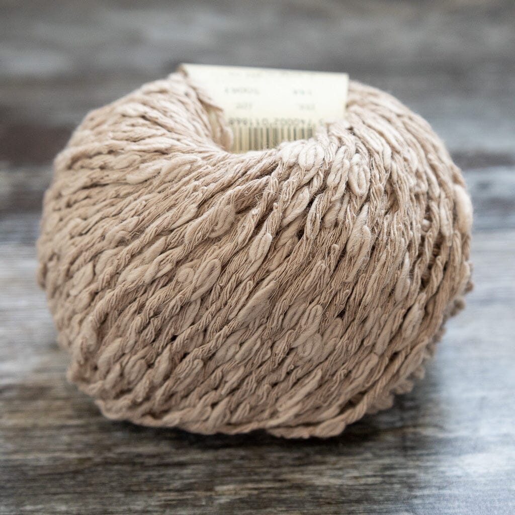 Ball of beige yarn on a wooden surface