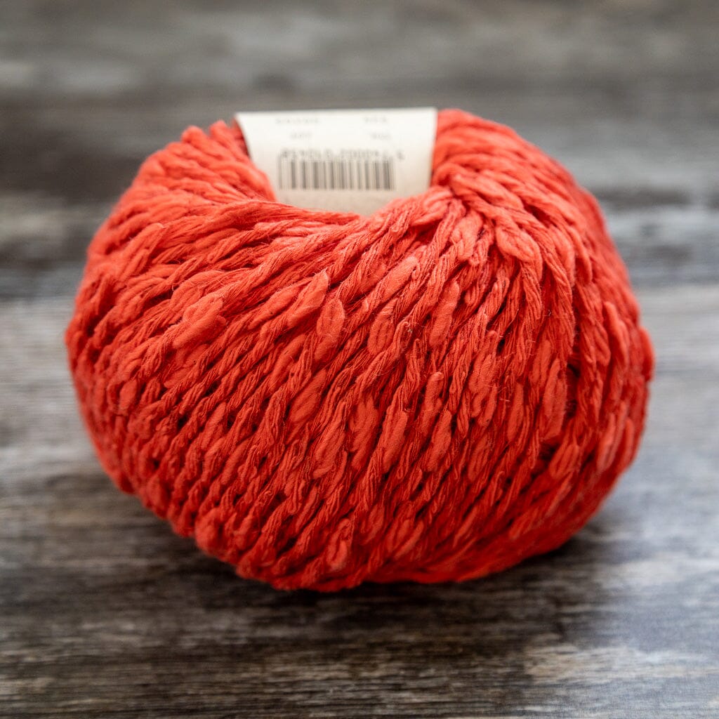 Red ball of yarn on a wooden surface