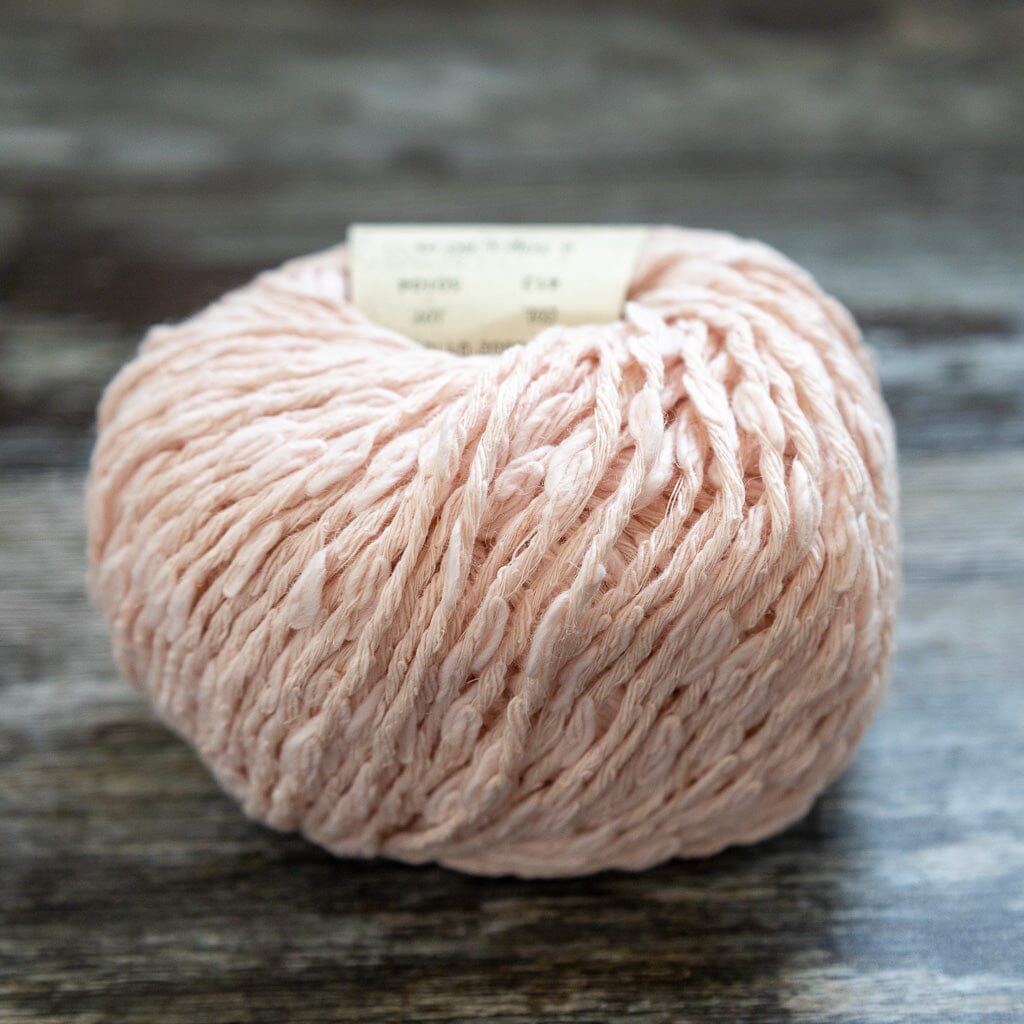 Ball of pink yarn on a wooden surface