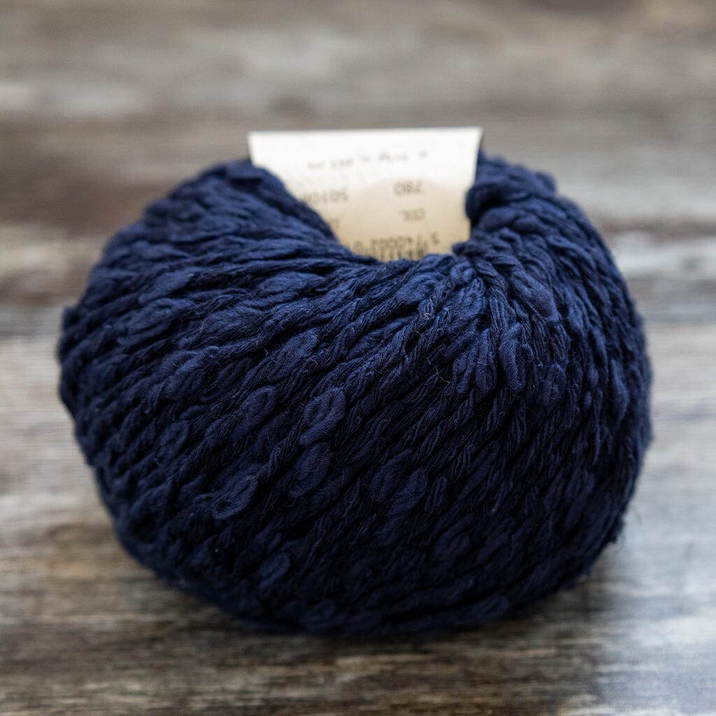 Navy blue yarn ball on a wooden surface