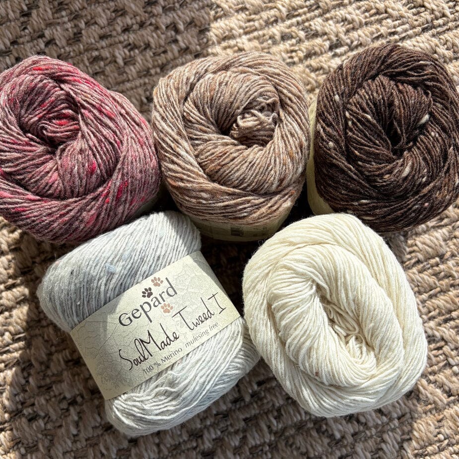 5 balls of tweed yarn on woven carpet with white label 'gepard soulmade tweed I'