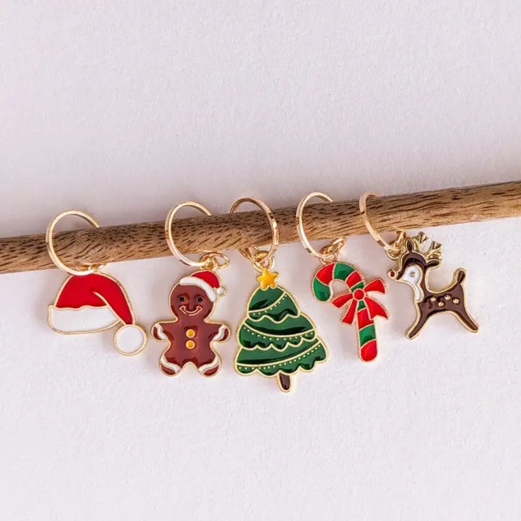 Set of Christmas-themed knitting stitch markers on a white background